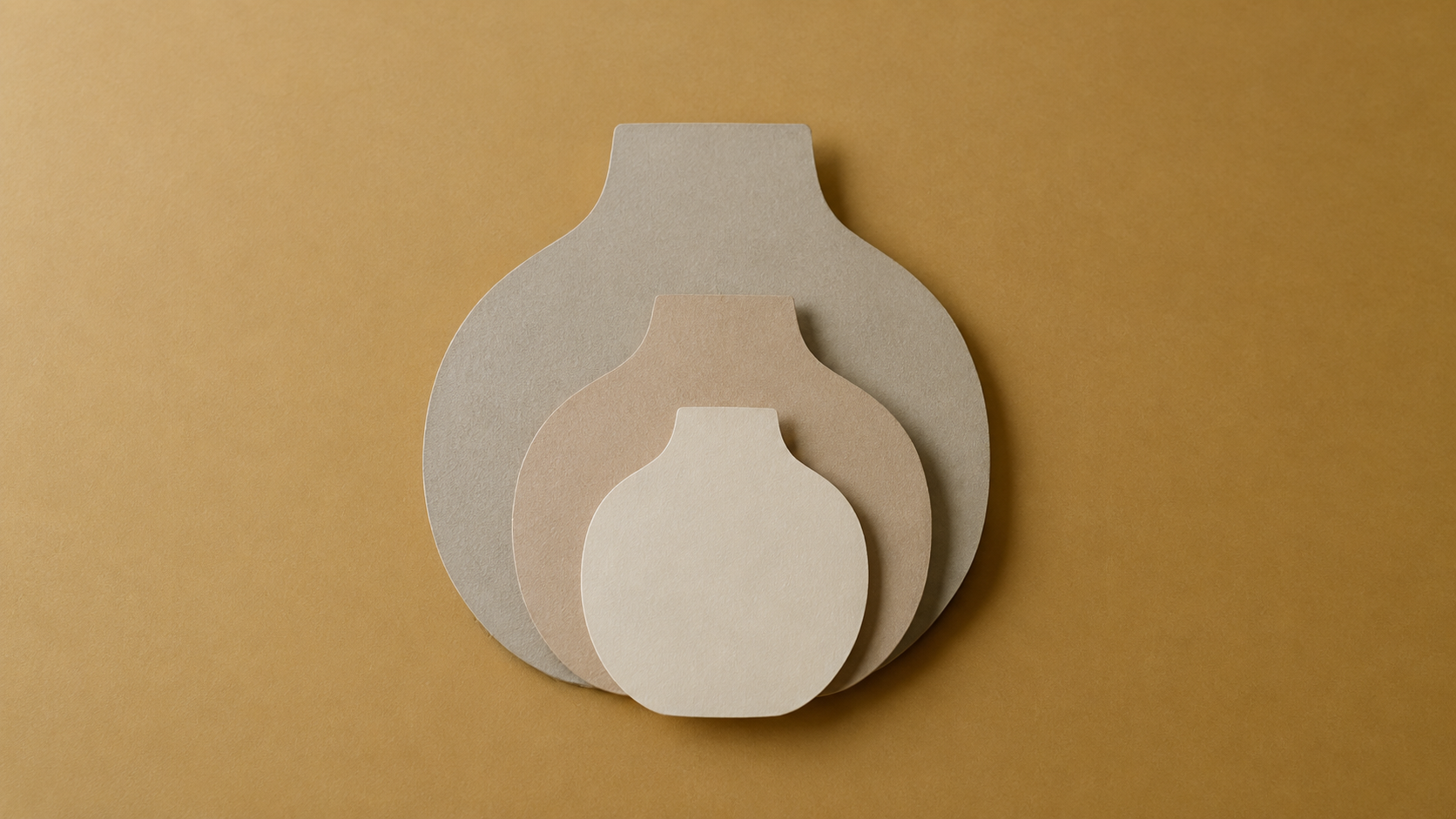 Three plain paper cutout shapes of one unlabelled object layered at different sizes on a flat muted ochre background